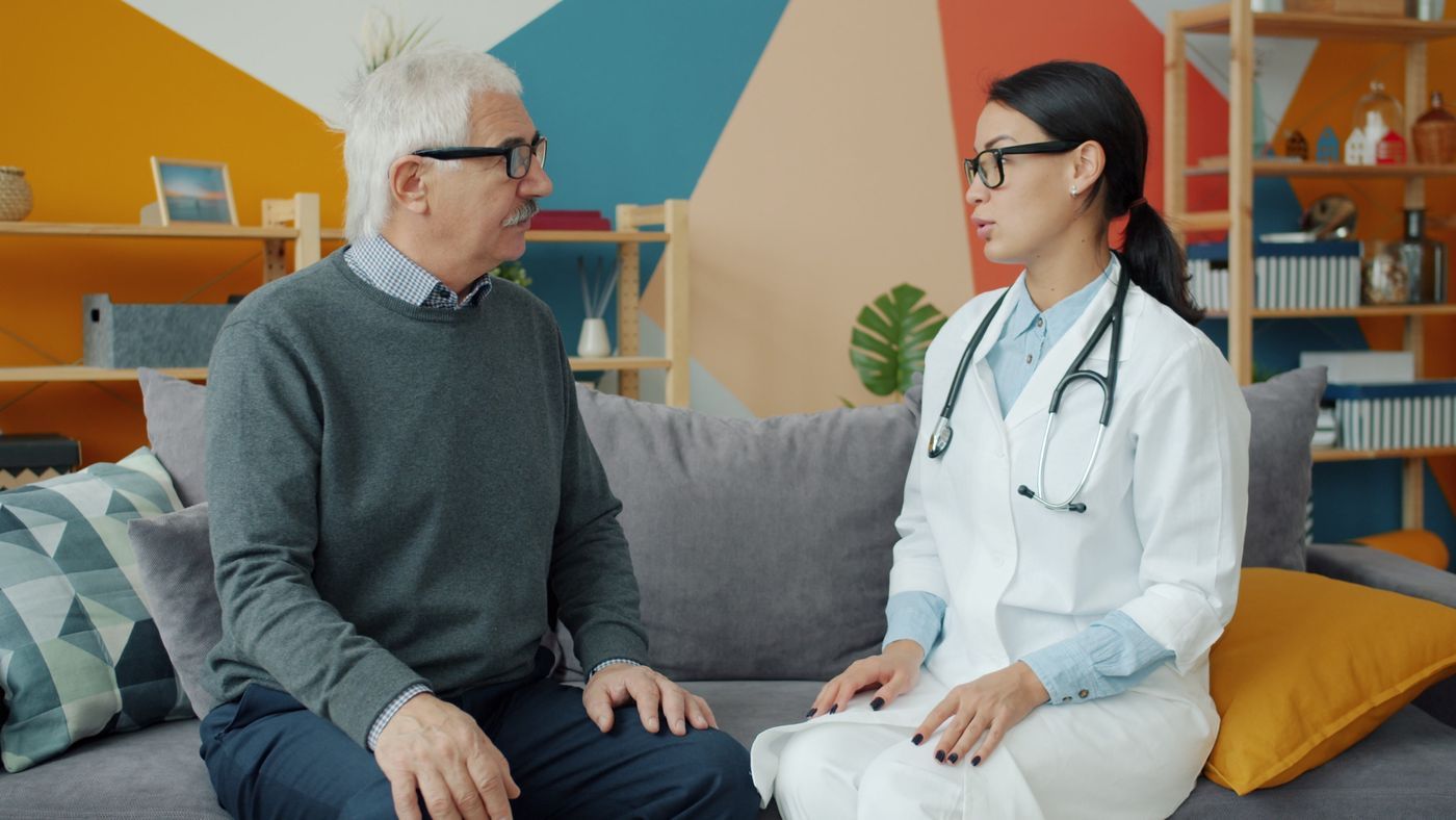 Uróloga conversando con un paciente de edad madura